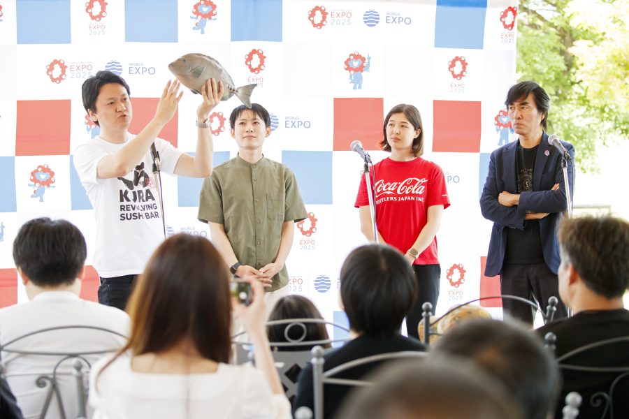 観客の前で4人のトークセッション。左端の男性が魚を左手に持ち解説している。